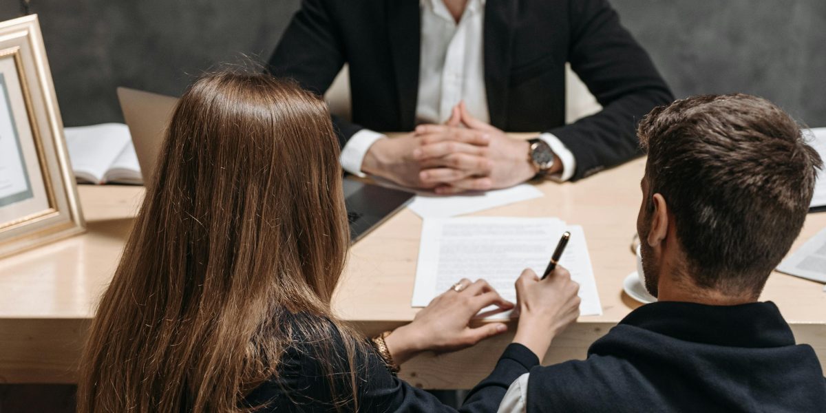 Two individuals, possibly a tenant and a landlord or agent, engaging in a polite but firm negotiation over a rental contract.