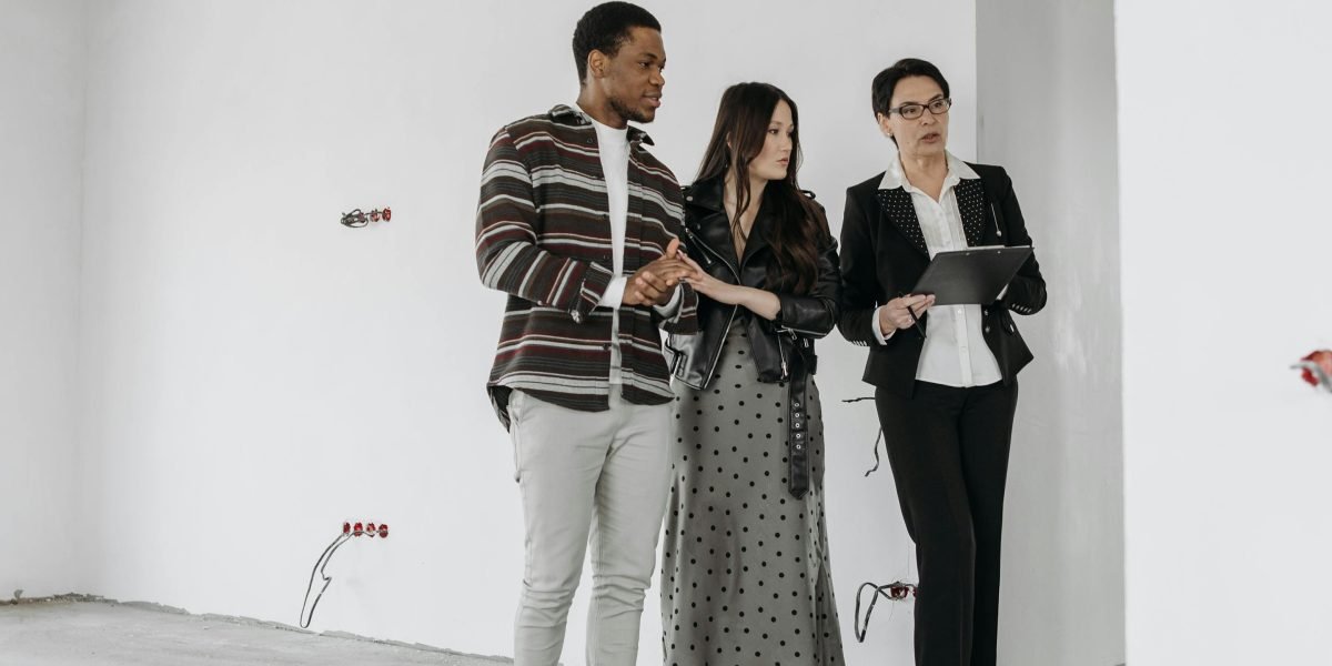 A real estate agent showing an apartment to prospective tenants, guiding them through the initial steps of the rental process.