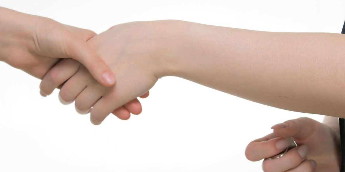 Two professionals shaking hands, symbolizing a successful business deal or partnership, highlighting the outcome of credibility and legal authorization.