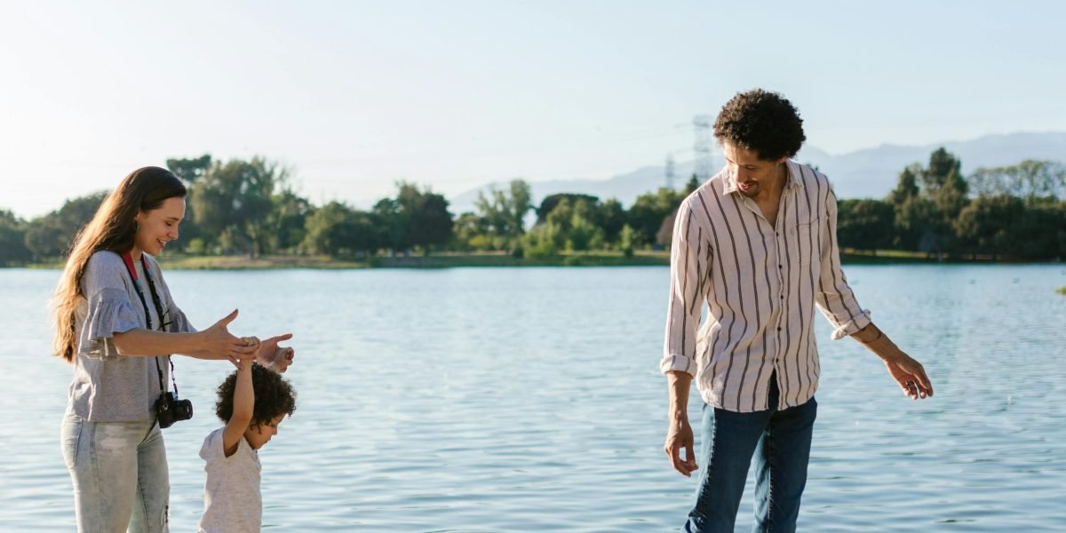 A happy family enjoys a sunny day in a community park, reflecting the lifestyle benefits of a chosen emirate.