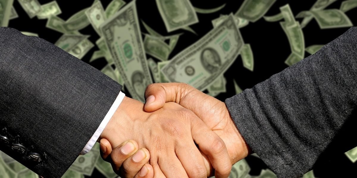 Professionals shaking hands across a desk, symbolizing a successful agreement and the completion of a property transaction.