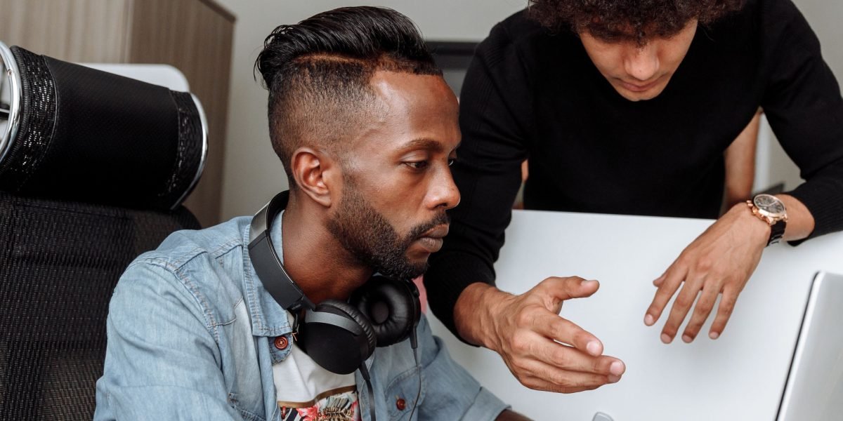 An experienced mentor guiding a younger professional in an office setting, illustrating support in overcoming career challenges.