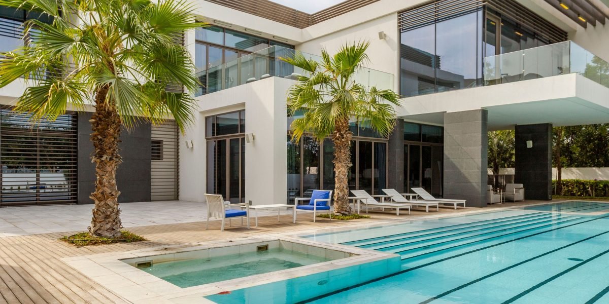 A modern 4-bedroom villa in Dubai, featuring large windows, a contemporary kitchen, and a private swimming pool, reflecting the luxurious lifestyle.