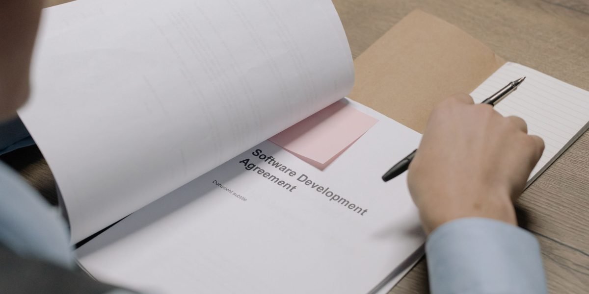 A person meticulously reviews legal contract documents, highlighting the need for expert guidance in complex real estate agreements.