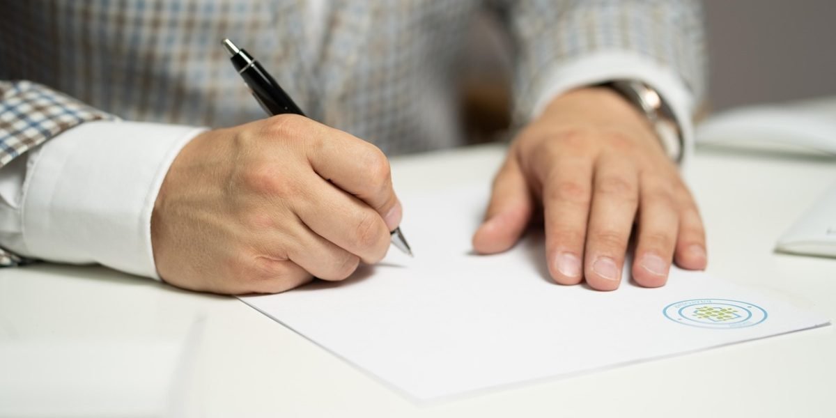 Individuals reviewing and signing important legal documents for a property purchase in Dubai.