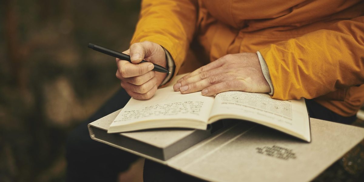 A person carefully reviewing multiple documents, symbolizing the diligent research required to choose the right real estate agency.