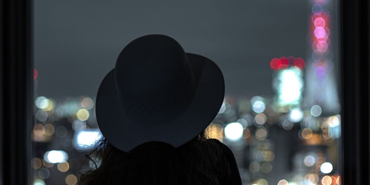 A person looking out over a city skyline, contemplating a big life decision like moving.