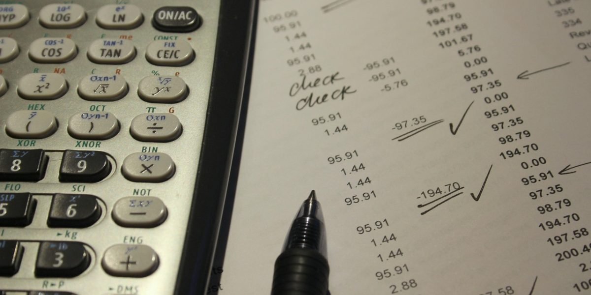 A person focused on financial documents and a calculator, making informed decisions about rental costs.