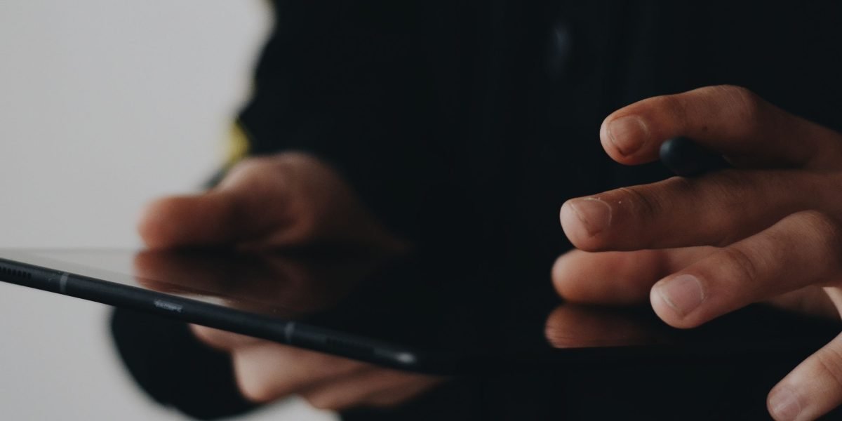 An individual diligently researching rental properties on a tablet, exploring various online platforms.